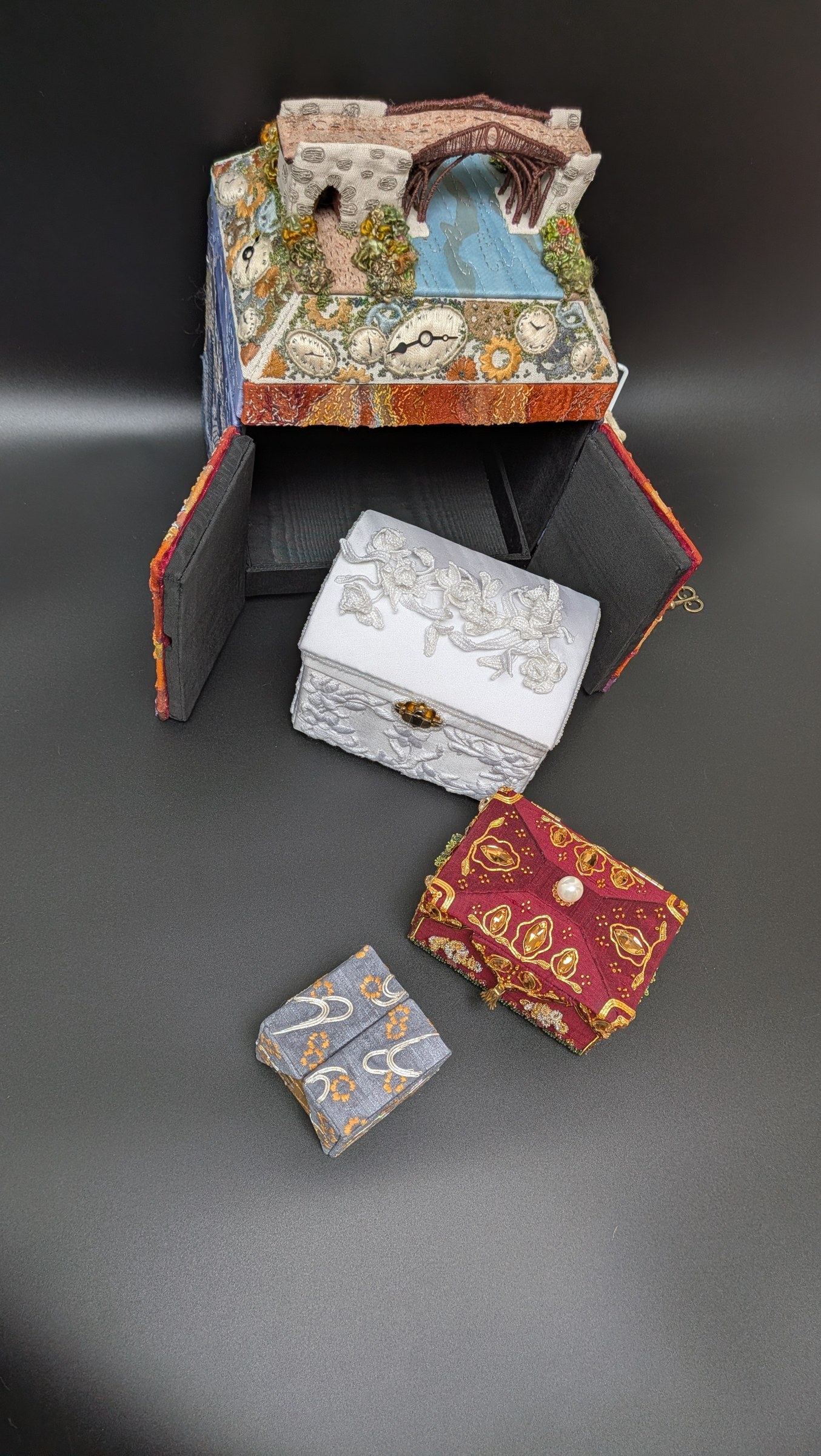 The four nested embroidered boxes displayed together
