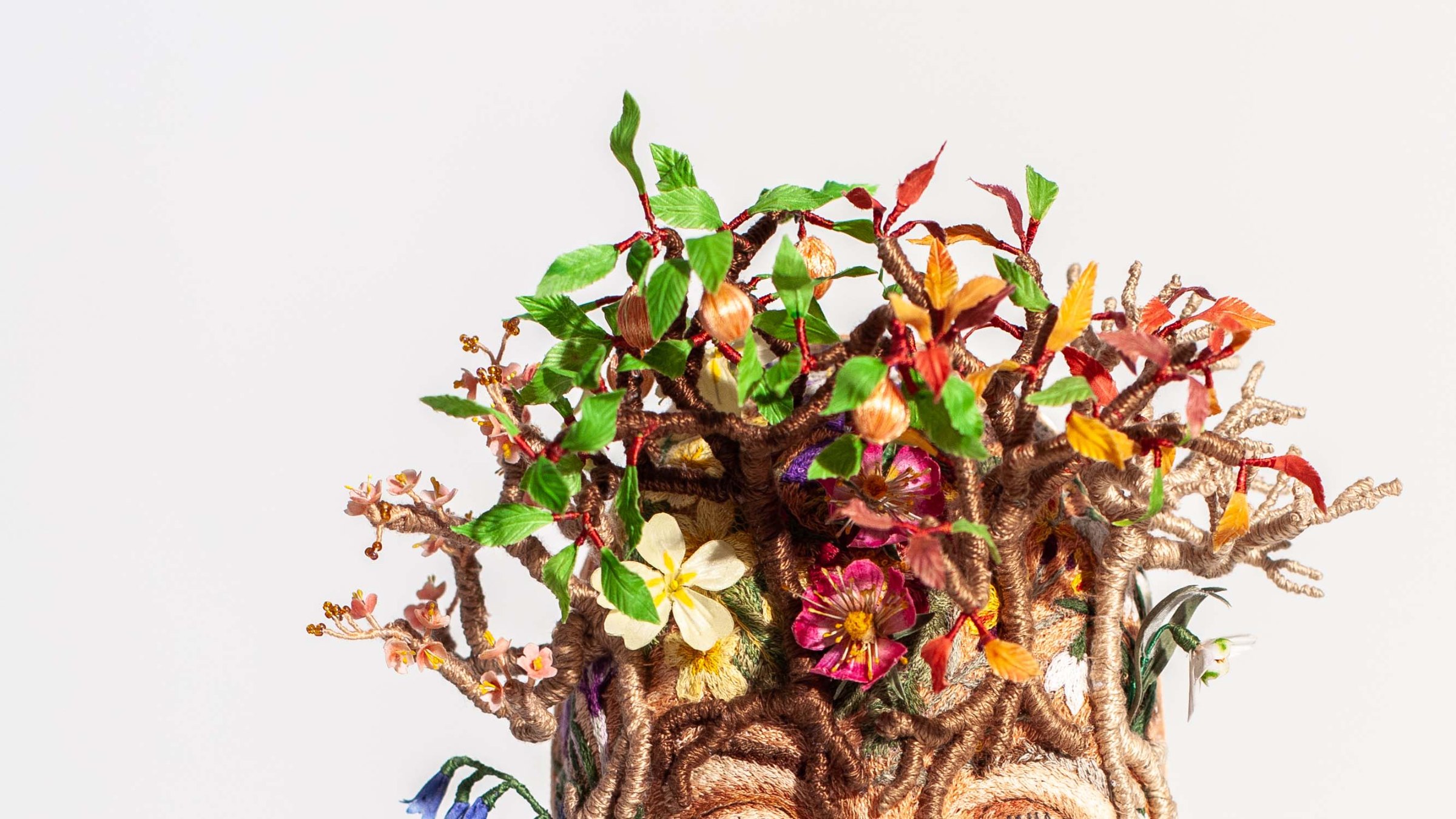 Handmade silk blossoms and wrapped branches forming the crown